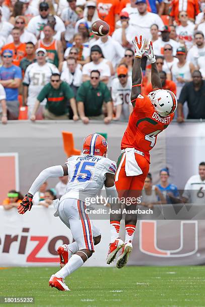 Loucheiz Purifoy of the Florida Gators defends as Phillip Dorsett of the Miami Hurricanes is unable to catch the pass from Stephen Morris on...