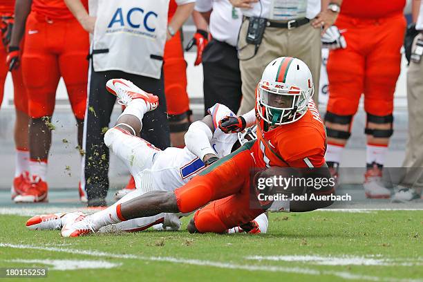 Allen Hurns of the Miami Hurricanes is tackled by Loucheiz Purifoy of the Florida Gators on September 7, 2013 at Sun Life Stadium in Miami Gardens,...