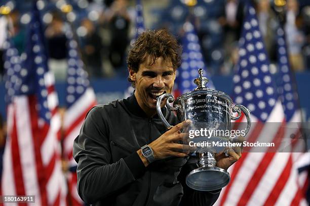 Rafael Nadal of Spain bites the trophy as he celebrates winning the men's singles final match against Novak Djokovic of Serbia on Day Fifteen of the...