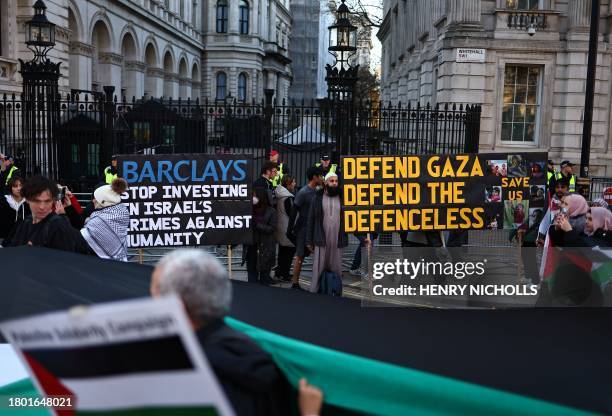 Protesters holding placards and Palestinian flags pass the gates to Downing Street as they take part in a 'National March For Palestine' in central...