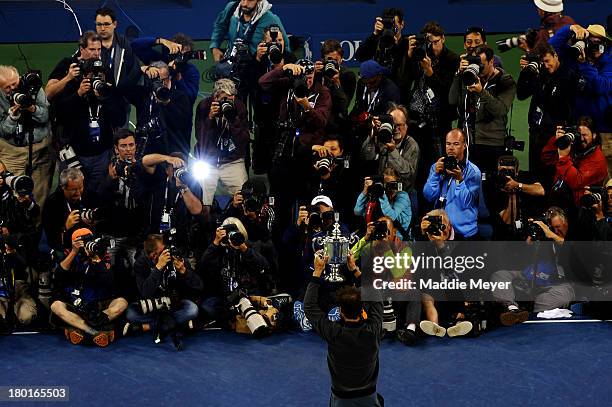 Photographers take pictures of Rafael Nadal of Spain as he poses with the US Open Championship trophy after winning the men's singles final match...