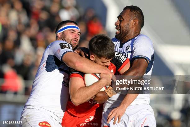 Toulon's French flanker Jules Coulon is tackled by Castres' Fijian lock Leone Nakarawa and Toulon's French prop Jean-Baptiste Gros during the French...