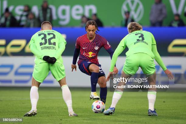 Leipzig's Dutch midfielder Xavi Simons vies for the ball with Wolfsburg's Swedish midfielder Mattias Svanberg and Wolfsburg's Belgian defender...