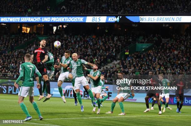 Bayer Leverkusen's German midfielder Robert Andrich jumps to head the ball during the German first division Bundesliga football match between Werder...