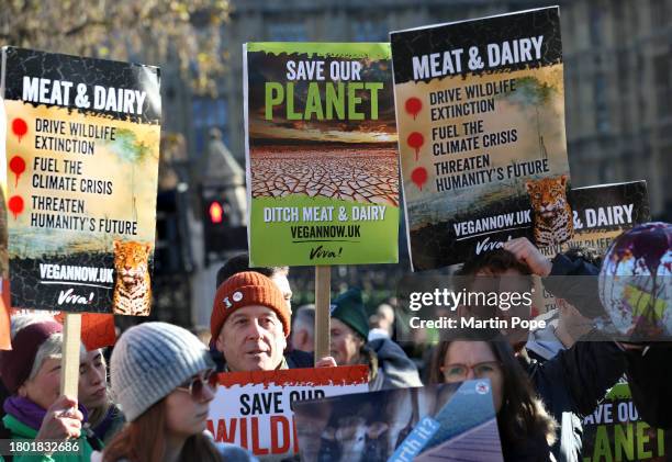 Protesters gather in a group holding signs highlighting the dangers of eating meat and dairy on November 25, 2023 in London, United Kingdom. The...