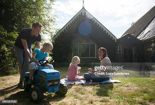 young family playing on their front lawn - masseria foto e immagini stock