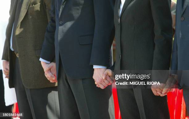 Madrid's Mayor Alberto Ruiz Gallardon holds hands with other assistants to the religious ceremony in memory of the victims of the 11 March blasts in...