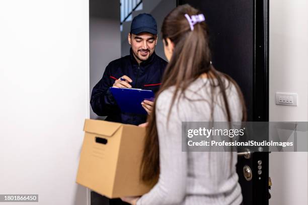 a young man from the delivery service is bringing a package to a female customer. - freedom of expression is a right and not granted stock pictures, royalty-free photos & images