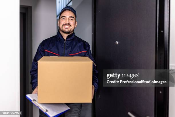 a delivery man is standing on a doorstep carrying a paper box. - freedom of expression is a right and not granted stock pictures, royalty-free photos & images