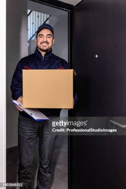 a young delivery guy is bringing a paper box to a customer. - freedom of expression is a right and not granted stock pictures, royalty-free photos & images