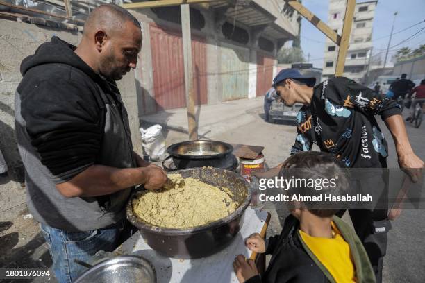 Residents fry falafel over a fire due to the lack of cooking gas due to the war and sell it to the displaced as it is one of the most famous...