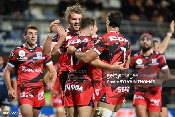 Oyonnax's French fullback Justin Bouraux is congratulated by teammates after scoring Oyonnax's second try during the French Top14 rugby union match...