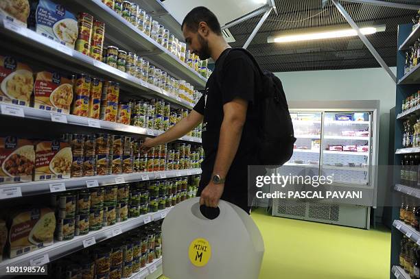 Un étudiant achète des produits dans une epicerie Mini M, un nouveau concept d'epicerie de proximité pour étudiants, le 09 septembre 2013 à Toulouse....