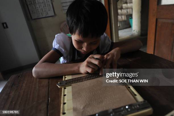 This photo taken on September 9, 2013 shows a blind student learning to write the Braille alphabet at the Yangon Education Centre for the Blind in...