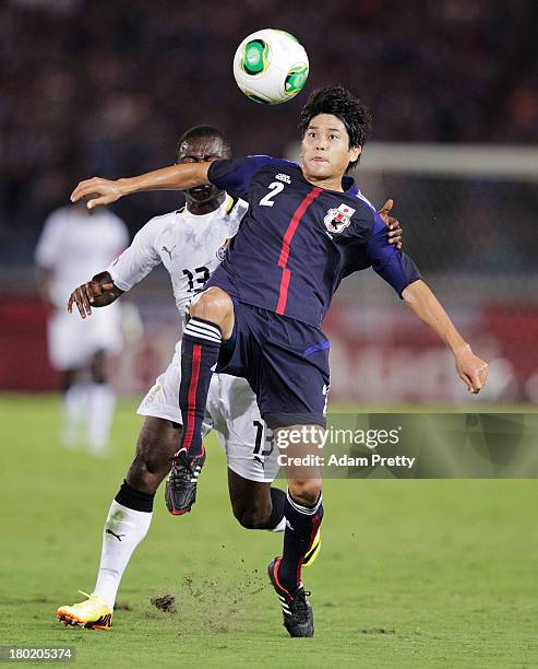 Atsuto Uchida of Japan is challenged by Frank Acheampong of Ghana during the international friendly match between Japan and Ghana at International...