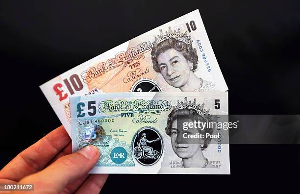 In this photo illustration, sample Polymer five and ten pound British banknotes are held during a news conference at the Bank of England on September...