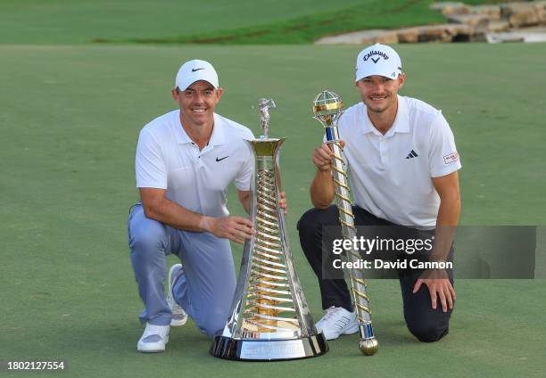 Nicolai Hojgaard of Denmark holds the DP World Tour Championship trophy with Rory McIlroy of Northern Ireland who won the DP World Tour Race to Dubai...