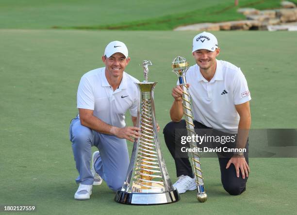 Nicolai Hojgaard of Denmark holds the DP World Tour Championship trophy with Rory McIlroy of Northern Ireland who won the DP World Tour Race to Dubai...