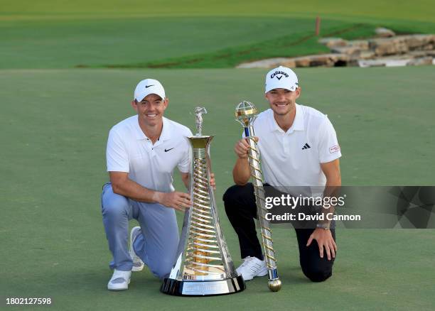 Nicolai Hojgaard of Denmark holds the DP World Tour Championship trophy with Rory McIlroy of Northern Ireland who won the DP World Tour Race to Dubai...