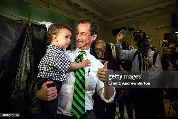 New York City mayoral hopeful Anthony Weiner exits the voting booth with his son, Jordan Weiner, after voting at his polling station on September 10,...