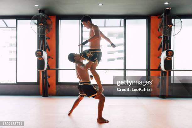 combat sport in thailand, woman boxing with her trainer at the gym - male feet pics stockfoto's en -beelden