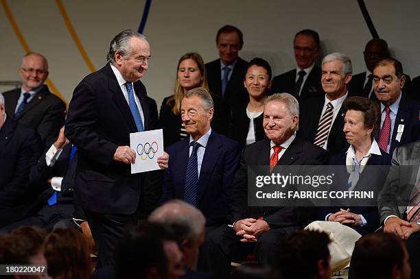 International Olympic Committee member Francisco Elizalde holds the enveloppe containing the name of the new IOC president during the announcement...