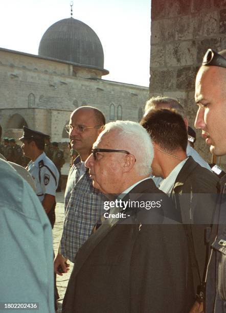 Israeli right-wing opposition leader Ariel Sharon is flanked by security guards as he leaves the Al-Aqsa mosque compound in Jerusalem's Old City 28...