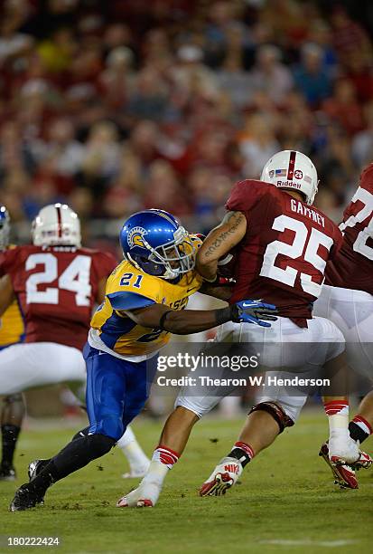 Tyler Gaffney of the Stanford Cardinal gets tackled by Bene Benwikere of the San Jose State Spartans during the third quarter at Stanford Stadium on...