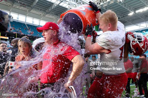 Head coach Jeff Brohm of the Louisville Cardinals receives a a gatorade bath after defeating the Miami Hurricanes at Hard Rock Stadium on November...