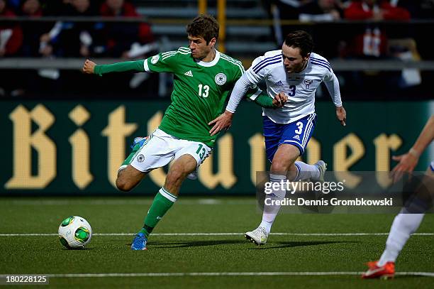 Thomas Mueller of Germany and Viljormur Davidsen of Faeroe Islands battle for the ball during the FIFA 2014 World Cup Qualifier match between Faeroe...