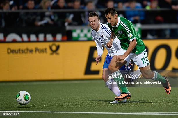 Miroslav Klose of Germany misses a chance at goal under the pressure of Viljormur Davidsen of Faeroe Islands during the FIFA 2014 World Cup Qualifier...