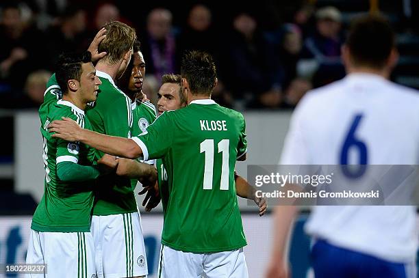 Per Mertesacker of Germany celebrates with teammates after scoring his team's first goal during the FIFA 2014 World Cup Qualifier match between...