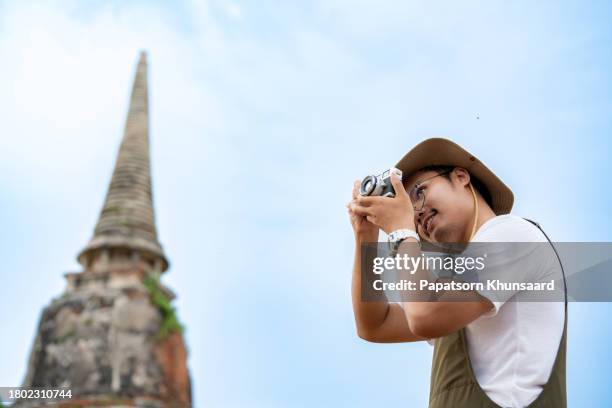 asiatischer reisender hat spaß während des urlaubs im tempel des ayutthaya-buddhas in thailand. - southeast asia stock-fotos und bilder