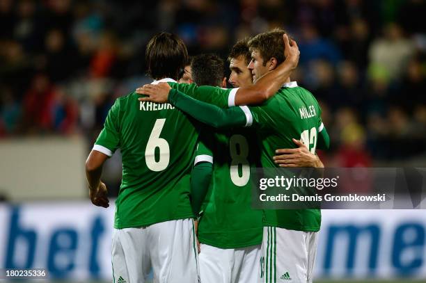 Mesut Oezil of Germany celebrates with teammates after scoring his team's second goal during the FIFA 2014 World Cup Qualifier match between Faeroe...