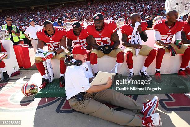 Linebackers Coach Jim Leavitt of the San Francisco 49ers talks with Eric Reid, Patrick Willis and NaVorro Bowman during the game against the Green...