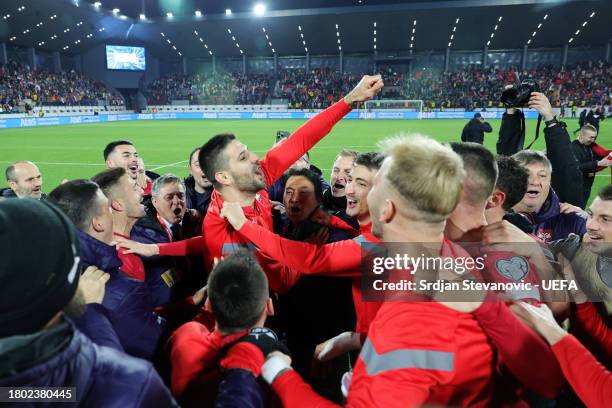 Aleksandar Mitrovic of Serbia celebrates with teammates and coaching staff at full-time following their teams draw and resulting qualification after...