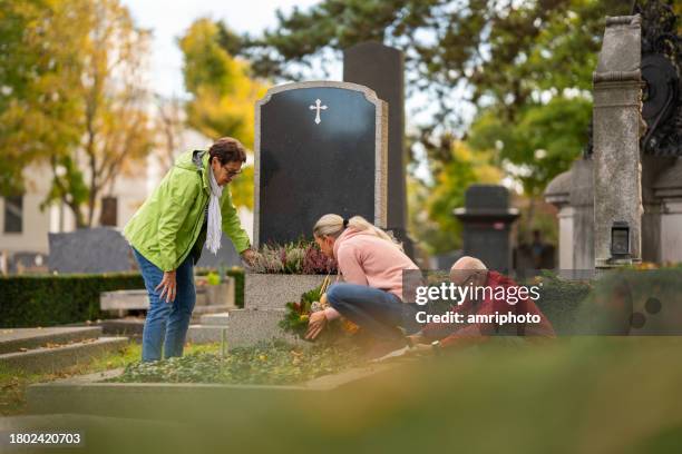 people working at grave on cemetery in autumn - tombstone stock pictures, royalty-free photos & images