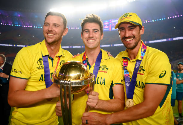 Josh Hazlewood, Pat Cummins and Mitchell Starc of Australia poses with the ICC Men's Cricket World Cup Trophy following the ICC Men's Cricket World...