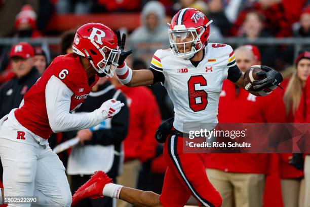 Wide receiver Jeshaun Jones of the Maryland Terrapins stiff arms defensive back Shaquan Loyal of the Rutgers Scarlet Knights after making a catch...