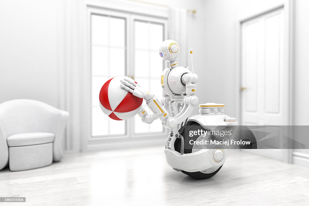 Robot looking at a red and white ball indoors