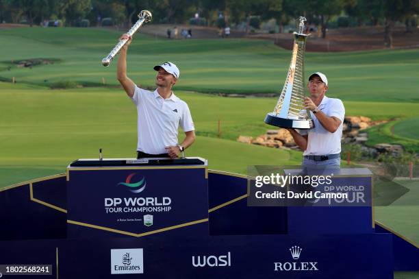 Nicolai Hojgaard of Denmark raises the DP World Tour Championship trophy with Rory McIlroy of Northern Ireland who won the DP World Tour Race to...