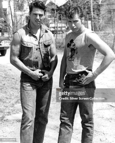 American actors Tom Cruise as Steve Randle, and Emilio Estevez, as Two-Bit Matthews, in a publicity still for 'The Outsiders', directed by Francis...