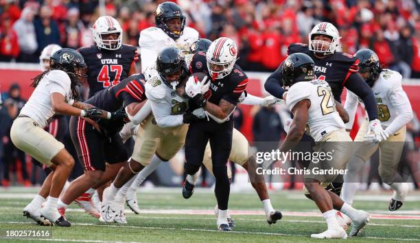 Ja'Quinden Jackson of the Utah Utes rushes the ball against Amari McNeill of the Colorado Buffaloes during the second half of their game at Rice...