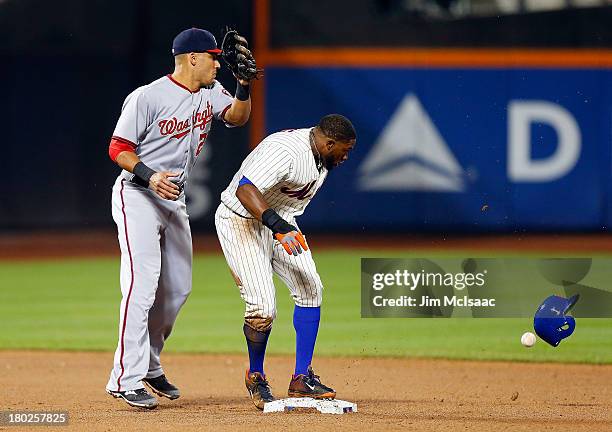 Eric Young Jr. #22 of the New York Mets loses his helmet at second base as Ian Desmond of the Washington Nationals can't come with a ball thrown for...