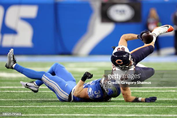Cole Kmet of the Chicago Bears gets tackled by Alex Anzalone of the Detroit Lions after a second quarter reception at Ford Field on November 19, 2023...