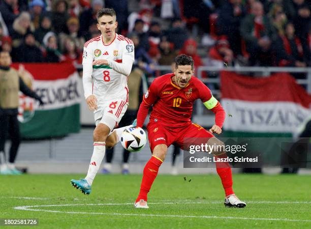 Stevan Jovetic of Montenegro competes for the ball with Adam Nagy of Hungary during the UEFA EURO 2024 qualifying round match between Hungary and...