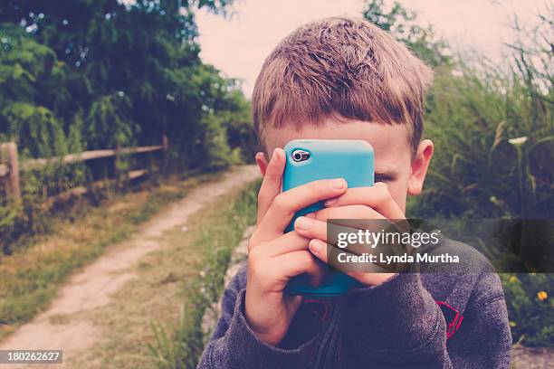 Young boy taking photo with mobile device