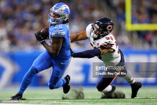 Jahmyr Gibbs of the Detroit Lions runs with the ball as T.J. Edwards of the Chicago Bears looks to make a tackle during the first half at Ford Field...