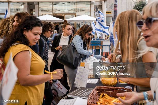 Woman seen wearing a yellow ribbon on her wrist to show solidarity with hostages held by Hamas in Tel Aviv. As the Israeli-Palestinian conflict...