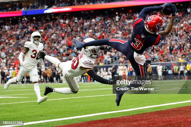 Tank Dell of the Houston Texans catches a pass for a touchdown in front of Marco Wilson of the Arizona Cardinals during the second quarter at NRG...